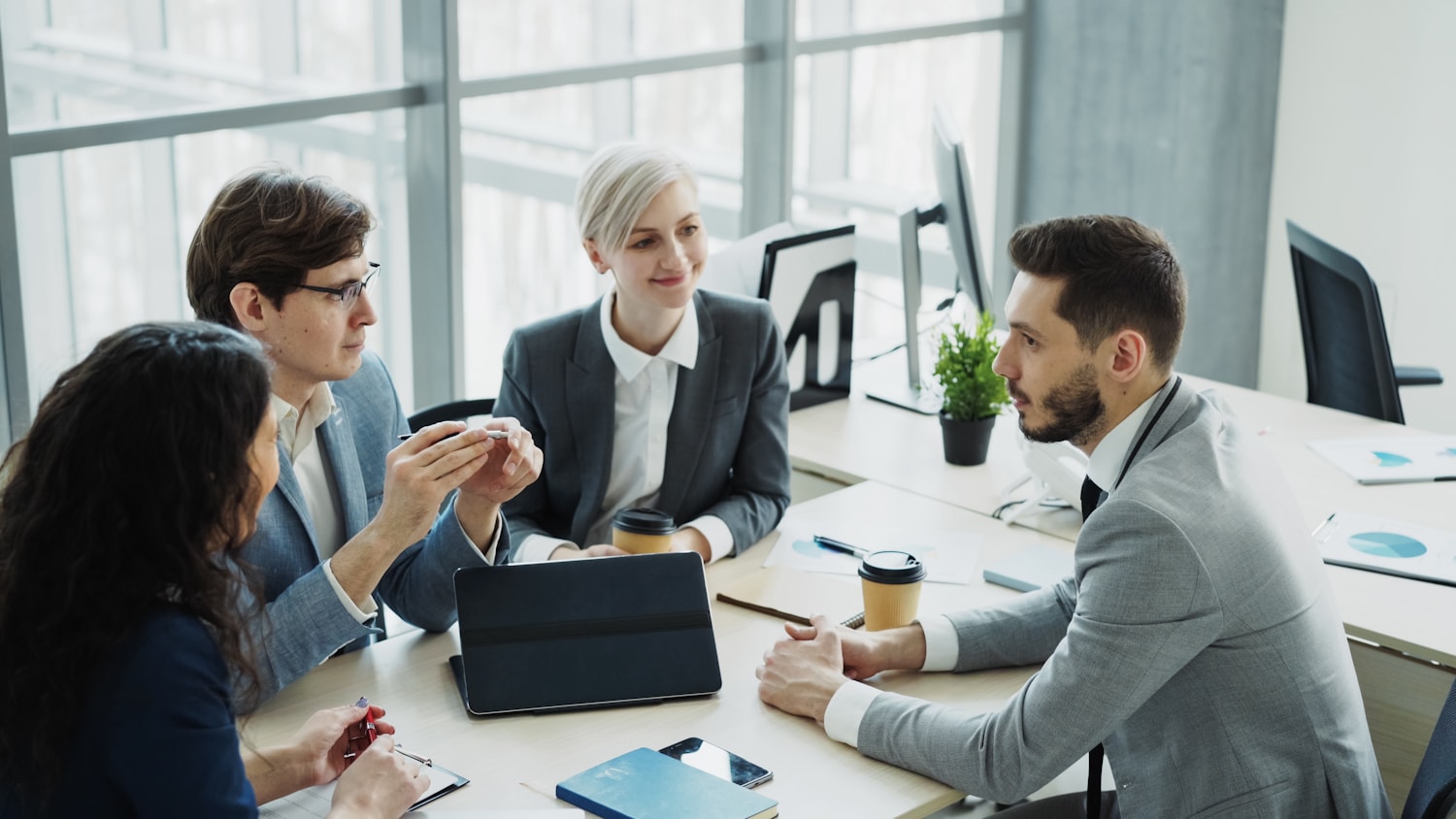A board election committee discussing candidate information around a meeting table